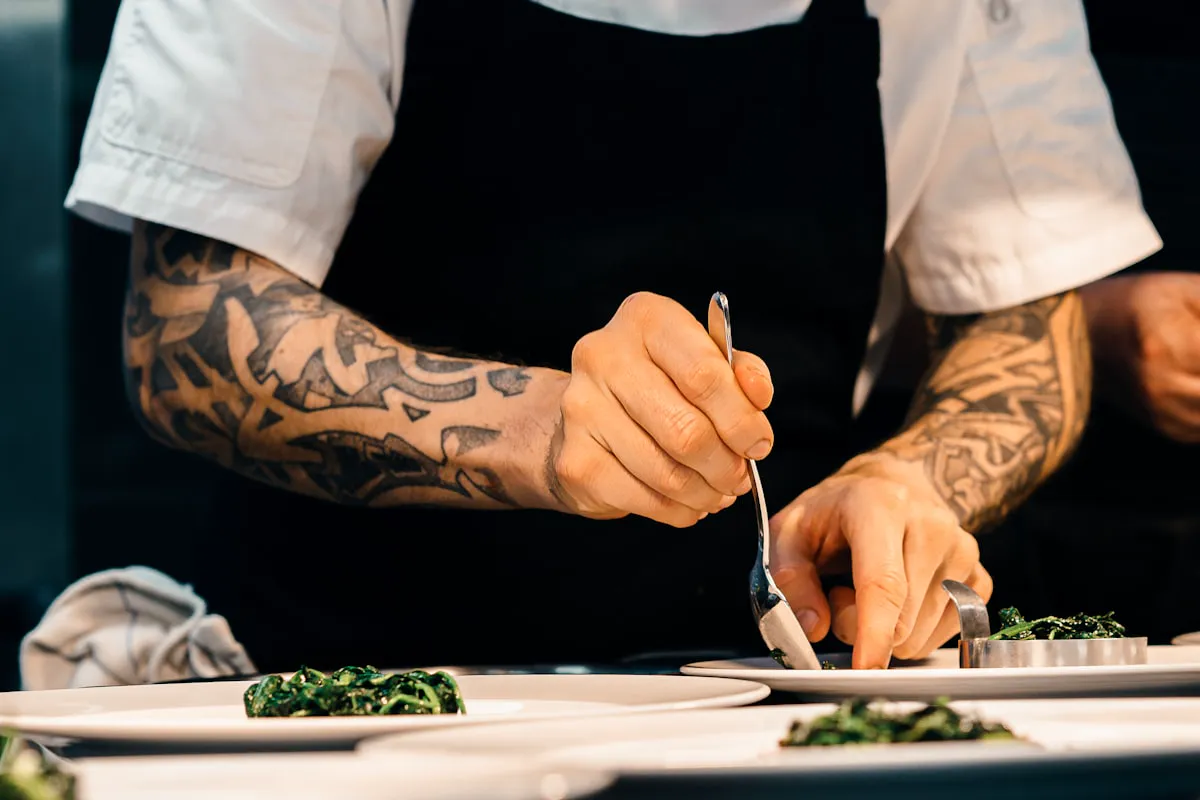 A cook's hands finishing a plate at the SAVU pass